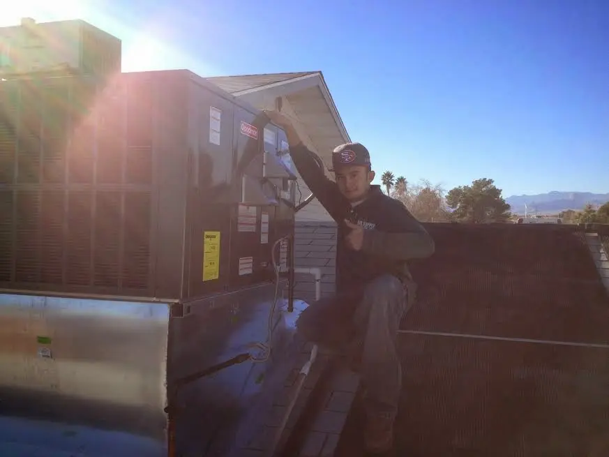HVAC technician performing AC Tune-Up on a rooftop unit in Westview