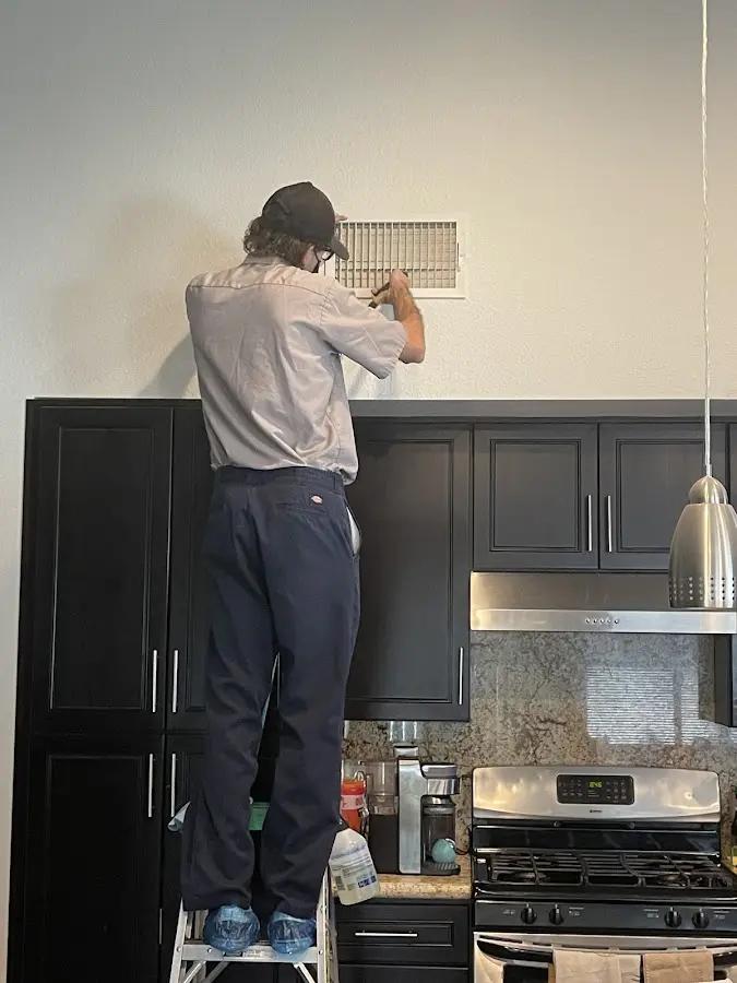 Technician inspecting an air vent during HVAC service in Westview